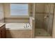 Bright bathroom features a garden tub and a tiled glass shower at 20101 Oakflower Ave, Tampa, FL 33647