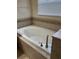 Relaxing bathtub with tiled surround and a window at 20101 Oakflower Ave, Tampa, FL 33647