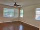Bedroom features wood floors, neutral walls, a ceiling fan, and three windows with blinds at 20101 Oakflower Ave, Tampa, FL 33647