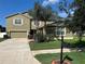 Well-maintained two-story home with lush lawn, mature trees, desert landscaping, and a two-car garage plus a one-car garage at 20101 Oakflower Ave, Tampa, FL 33647