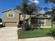 Well-maintained two-story home with lush lawn, mature trees, desert landscaping, and a two-car garage plus a one-car garage at 20101 Oakflower Ave, Tampa, FL 33647