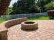 Brick patio featuring a built-in fire pit and a backyard with a white privacy fence at 20101 Oakflower Ave, Tampa, FL 33647