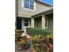 Front entrance of home features desert landscaping leading up to the covered entry with decorative pillars at 20101 Oakflower Ave, Tampa, FL 33647