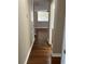 Hallway with hardwood flooring leading to an open area with ceiling fan at 20101 Oakflower Ave, Tampa, FL 33647