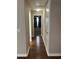 Hallway with wood floors leads to a bedroom with black curtains at 20101 Oakflower Ave, Tampa, FL 33647