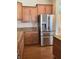 A spacious kitchen features a stainless steel refrigerator, wooden cabinets, and granite countertops at 20101 Oakflower Ave, Tampa, FL 33647