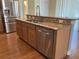 Kitchen island boasts granite counters, stainless steel appliances, and wood cabinets over hardwood floors at 20101 Oakflower Ave, Tampa, FL 33647