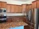An open kitchen features granite countertops, stainless steel appliances, and wooden cabinets at 20101 Oakflower Ave, Tampa, FL 33647