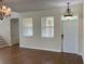 Open living room with hardwood floors, two windows, a white front door, and chandelier at 20101 Oakflower Ave, Tampa, FL 33647