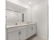 Modern bathroom featuring double vanity and a tiled shower at 22359 Storybook Cabin Way, Land O Lakes, FL 34637