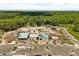 Aerial view of the new community clubhouse and pool under construction surrounded by lush forest at 22359 Storybook Cabin Way, Land O Lakes, FL 34637