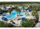 Aerial view of community pool with water park features and palm trees at 22359 Storybook Cabin Way, Land O Lakes, FL 34637
