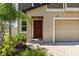 The property features a brick walkway, a red front door, and manicured landscaping at 22359 Storybook Cabin Way, Land O Lakes, FL 34637