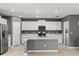 Kitchen featuring stainless steel appliances, white cabinets, a kitchen island, and tile flooring at 22359 Storybook Cabin Way, Land O Lakes, FL 34637