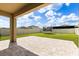Covered patio with brick pavers looks out onto a fenced backyard at 22359 Storybook Cabin Way, Land O Lakes, FL 34637