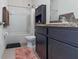 Bathroom with a shower-tub combo, tiled walls, dark cabinets and tan tile flooring at 2699 Suncoast Blend Dr, Odessa, FL 33556