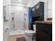 Clean bathroom features a shower, toilet, dark cabinets, and neutral tile flooring at 2699 Suncoast Blend Dr, Odessa, FL 33556