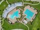 Aerial view of community pools, sundeck, and lounge areas surrounded by manicured lawns and landscaping at 2699 Suncoast Blend Dr, Odessa, FL 33556