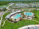 Aerial view of resort style community pools with beach entry and separate lap pool surrounded by beautiful landscaping at 2699 Suncoast Blend Dr, Odessa, FL 33556
