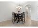 Cozy dining area with dark wood table and seating, complemented by a stylish chandelier and tile floors at 2699 Suncoast Blend Dr, Odessa, FL 33556