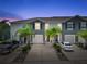 Beautiful townhomes, framed by palm trees, featuring well-kept driveways and inviting exteriors at twilight at 2699 Suncoast Blend Dr, Odessa, FL 33556