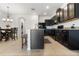Well-equipped kitchen features dark cabinetry, granite countertops, and an island with seating, seamlessly flowing into the dining area at 2699 Suncoast Blend Dr, Odessa, FL 33556