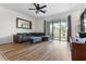 Spacious living room featuring hardwood floors, a comfortable couch, and sliding glass doors to the outside at 2699 Suncoast Blend Dr, Odessa, FL 33556