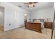 Well-lit main bedroom with a ceiling fan, ensuite bathroom, and a large bed frame at 2699 Suncoast Blend Dr, Odessa, FL 33556