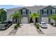 A front exterior view of grey two-story townhomes featuring two car driveways and palm tree landscaping at 2699 Suncoast Blend Dr, Odessa, FL 33556