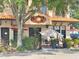 Charming cafe exterior featuring outdoor seating under umbrellas, surrounded by lush greenery, creates a welcoming ambiance at 2707 56Th S St, Gulfport, FL 33707