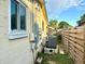 Side of the house with a window, utilities, and a wooden fence at 2707 56Th S St, Gulfport, FL 33707