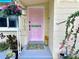 Close-up of front entrance with pastel door, colorful welcome mat, and decorative plants at 2707 56Th S St, Gulfport, FL 33707