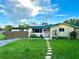 Charming home with a stone walkway, lawn, solar panels and a wooden fence at 2707 56Th S St, Gulfport, FL 33707