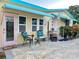 Charming exterior of home featuring a cozy front porch area with seating, a pink door and blue awnings at 2707 56Th S St, Gulfport, FL 33707