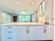 Bright kitchen featuring white cabinets with long brass handles and light stone countertops at 2707 56Th S St, Gulfport, FL 33707