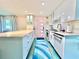 Modern kitchen with white cabinetry, stone countertops, stainless appliances, and colorful runner at 2707 56Th S St, Gulfport, FL 33707
