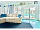 Cozy living room with a cream sectional, view of the pool and patio through large windows and sliding glass door at 2707 56Th S St, Gulfport, FL 33707