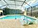 Screened-in pool area features lounge chairs, in-pool seating, and lush landscaping at 2707 56Th S St, Gulfport, FL 33707