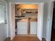 Functional laundry area equipped with washer, dryer, and shelving, conveniently located near the entrance at 2900 Grovewood Blvd # A, Palm Harbor, FL 34683