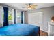 A comfortable bedroom features neutral walls, wooden floors, a ceiling fan, and a double window with sheer curtains at 3113 Chamblee Ln, Clearwater, FL 33759