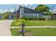 Home featuring nautical decor, lush landscaping, and a charming red front door at 3113 Chamblee Ln, Clearwater, FL 33759