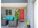 Inviting front porch with outdoor seating and a vibrant red door, complemented by stone accents at 3113 Chamblee Ln, Clearwater, FL 33759