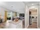Bright kitchen with stainless steel appliances, granite island and view to dining room and laundry room at 3113 Chamblee Ln, Clearwater, FL 33759