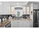 Bright kitchen showcasing white cabinets, granite countertops, stainless steel appliances, and a stylish backsplash at 3113 Chamblee Ln, Clearwater, FL 33759