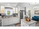 Well-lit kitchen featuring white cabinets, stainless steel appliances, granite counters and decorative island at 3113 Chamblee Ln, Clearwater, FL 33759