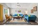 Bright living room with comfortable blue sofas, a decorative coffee table, and a ceiling fan at 3113 Chamblee Ln, Clearwater, FL 33759