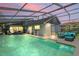 Relaxing screened pool area with comfortable seating, covered patio, and views of the home's exterior at 3113 Chamblee Ln, Clearwater, FL 33759