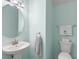 Stylish powder room with modern fixtures, pedestal sink, and tranquil turquoise walls at 3115 Gina Ct, Holiday, FL 34691