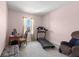 This bedroom is staged with a treadmill, desk, and chair at 3115 Gina Ct, Holiday, FL 34691