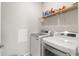 This laundry room features a washer, dryer, and shelving at 3115 Gina Ct, Holiday, FL 34691